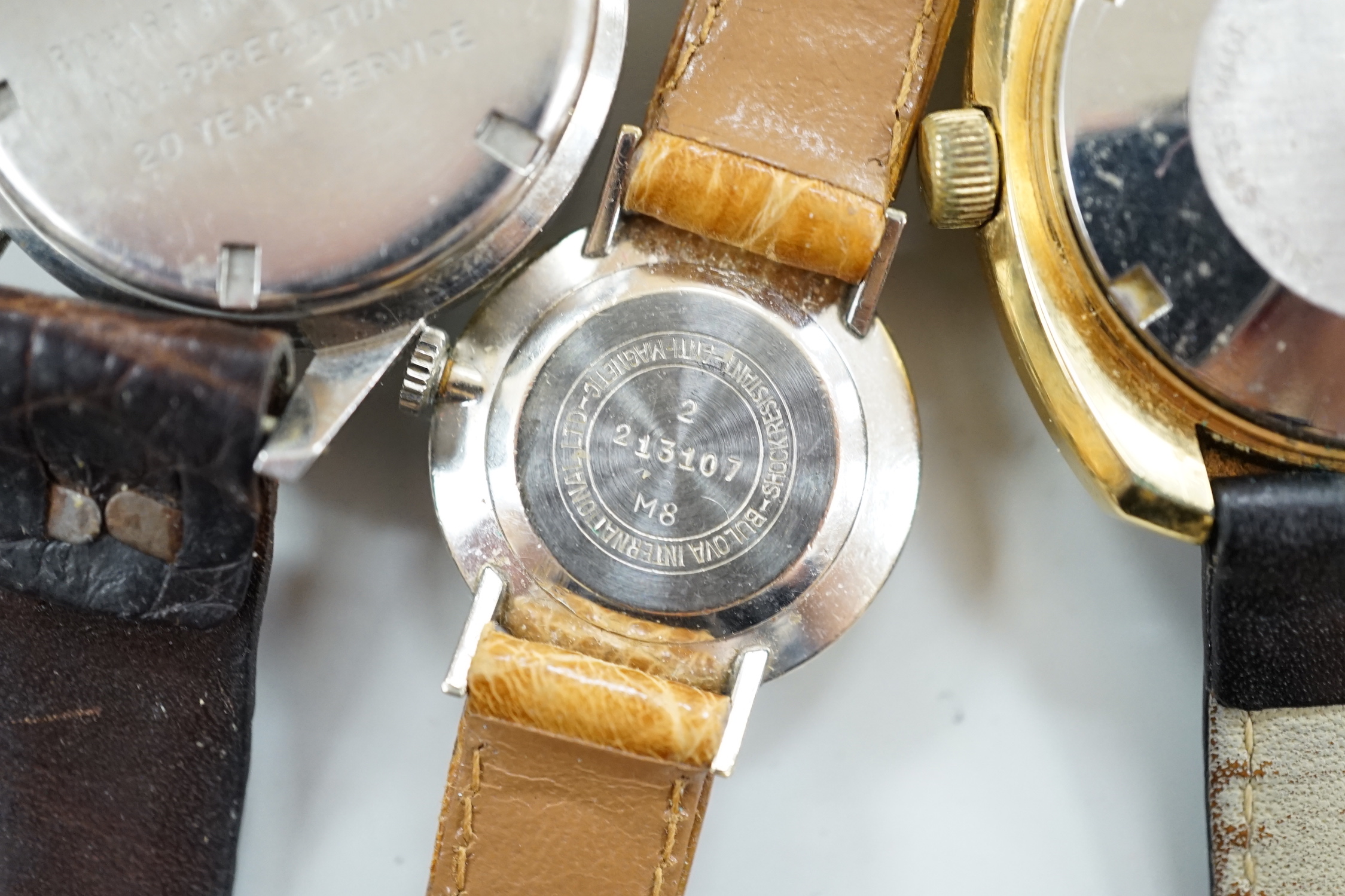 Three assorted gentleman's steel or gilt wrist watches, including retailed by Buhre and a lady's steel manual wind Bulova watch.